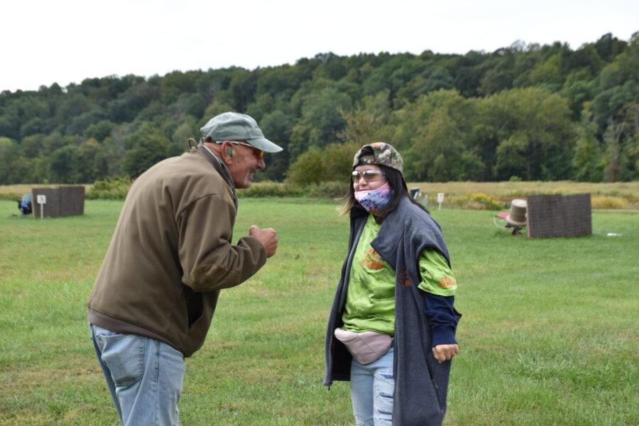 Two people talking in grassy outdoor field