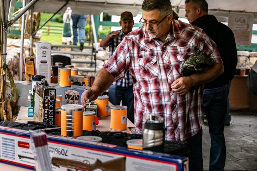 Man examining camping lanterns at market stall