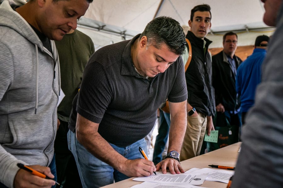 Man signing papers at crowded registration table