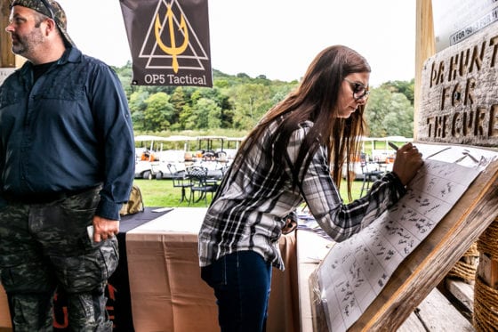 Woman writing on display board at outdoor booth