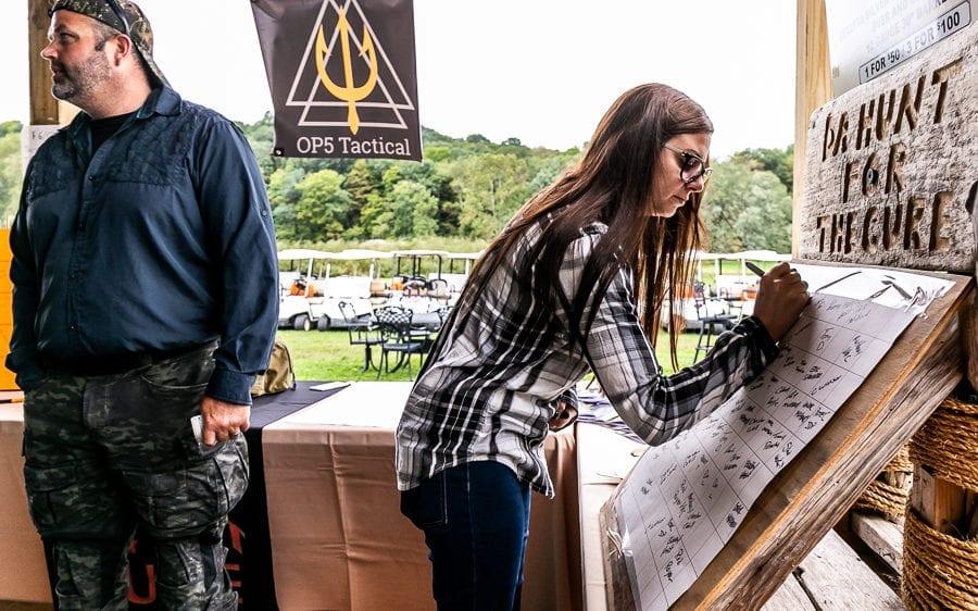 Woman writing on display board at outdoor booth