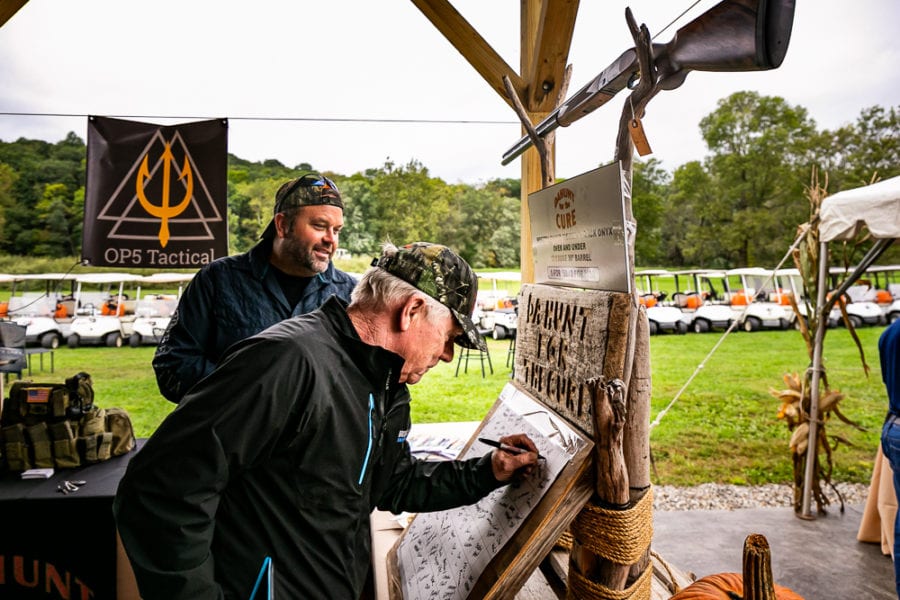 Man signing board at outdoor tactical booth