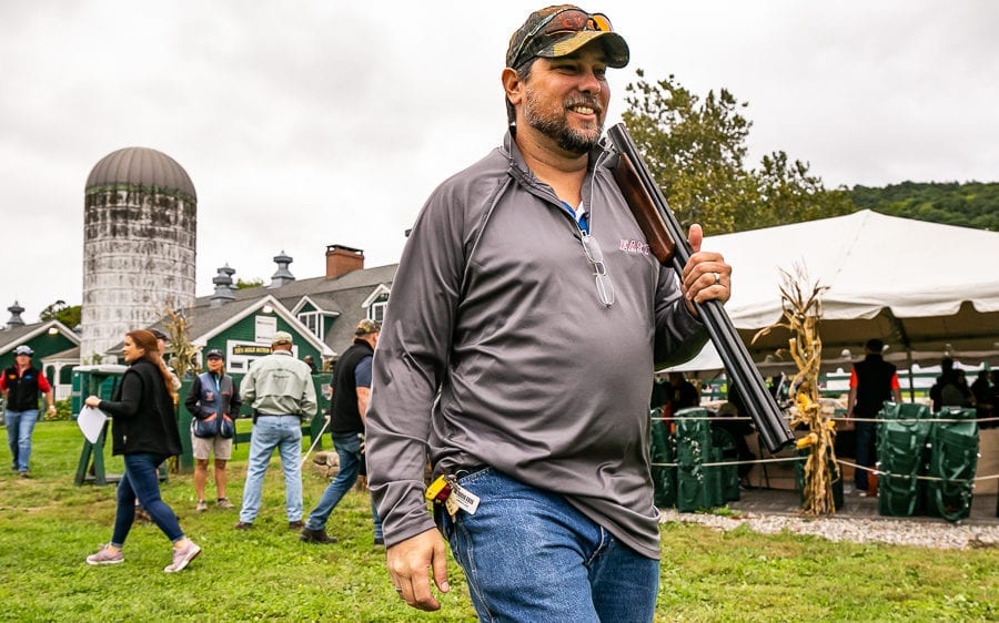 Smiling man with shotgun at rural fair
