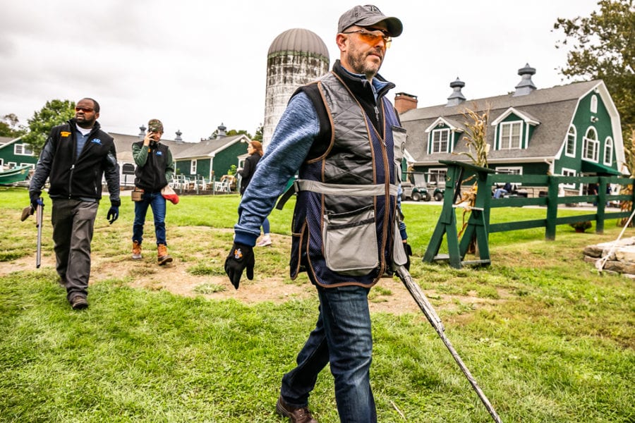 Man using metal detector in front of barn