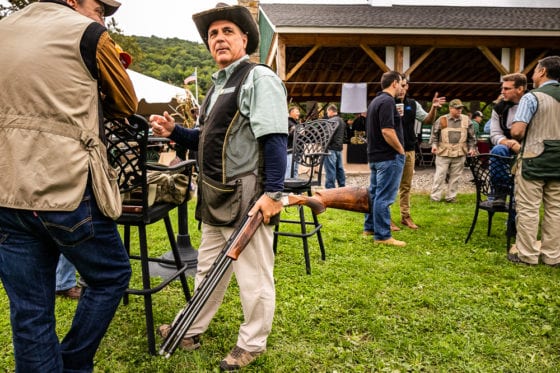 Man holding shotgun at outdoor shooting event