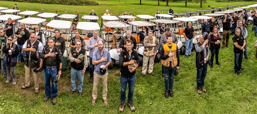 People standing beside rows of parked golf carts