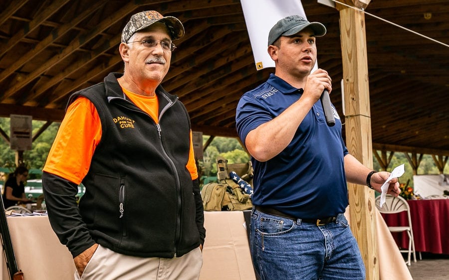 Two men speaking at outdoor pavilion