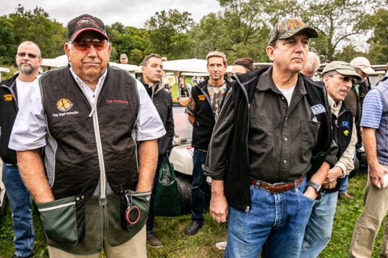 Men gathered by golf carts at outdoor event