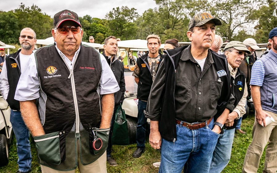 Men gathered by golf carts at outdoor event