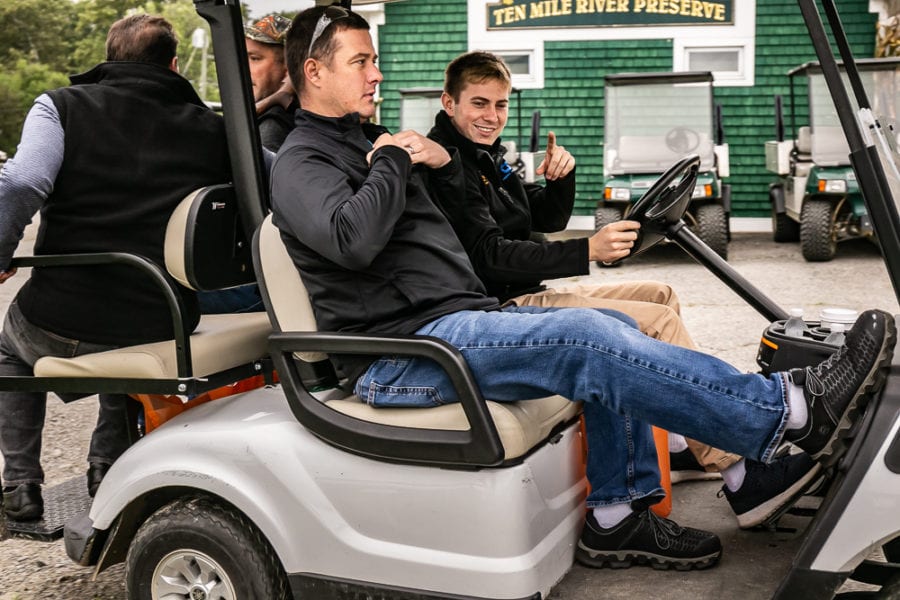 Two men riding in a golf cart
