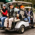 Hunters with shotguns in golf cart