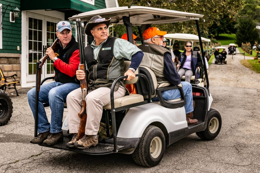 Hunters with shotguns in golf cart